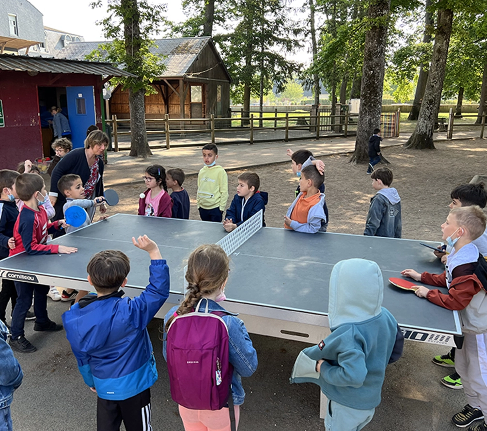 Enfants autour des tables de ping-pong fourni pour le programme 1 école 1 table